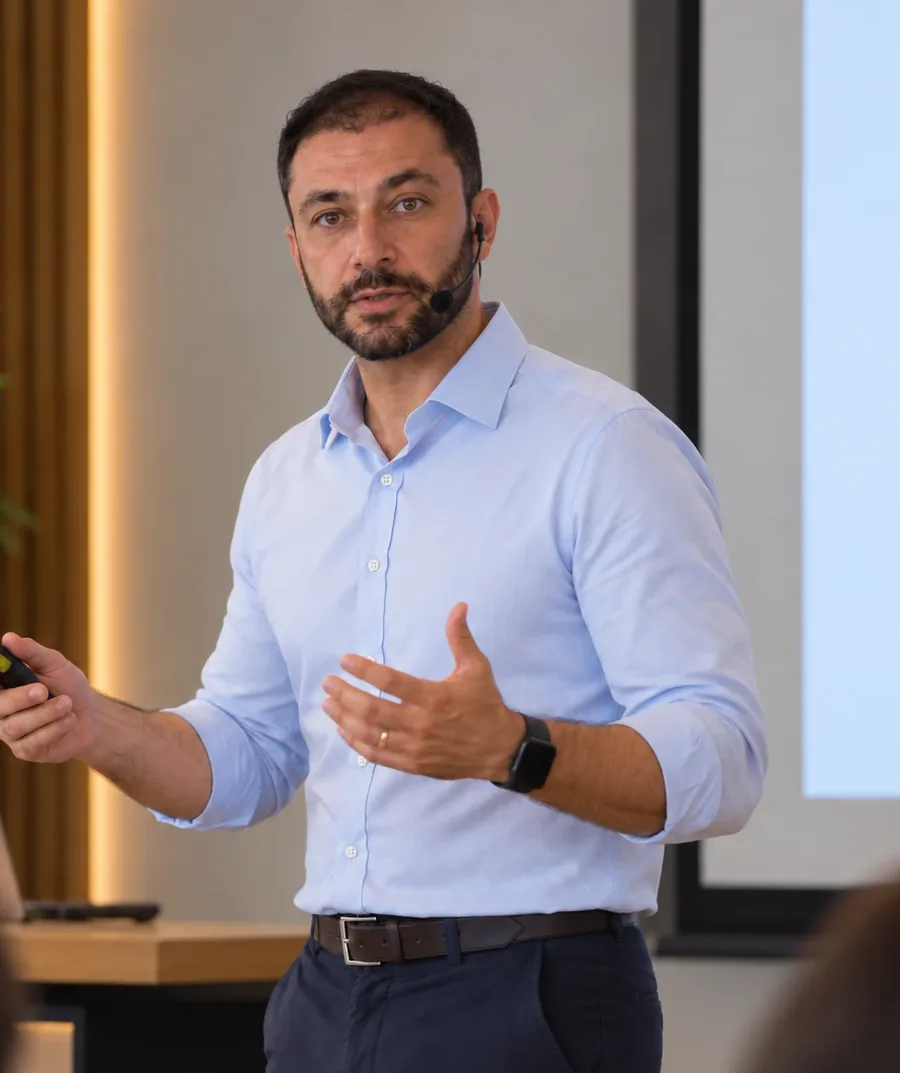 José Dantas giving a talk, wearing a headset microphone and holding a presentation clicker